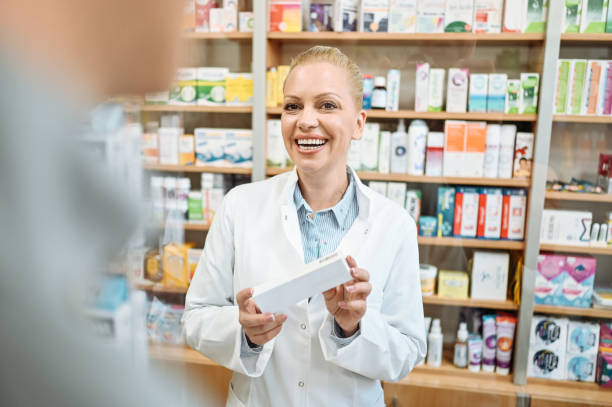 istock Pharmacist holding white medicine box and serving customer 1658915351