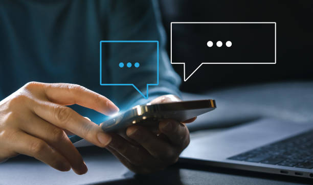 istock Human hand using smartphone typing Live chat chatting and social network concepts, chatting conversation working at home in chat box icons pop up. Social media marketing technology concept 1658931386