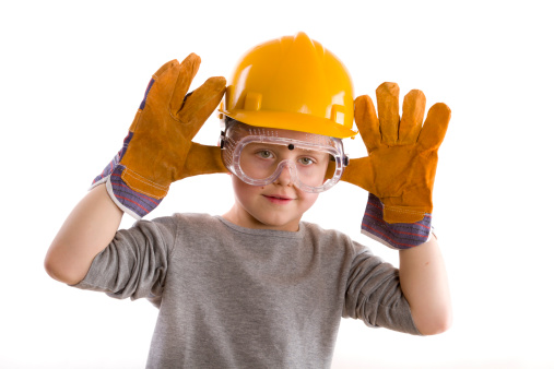 young boy wearing hard hat with glowes and goggles