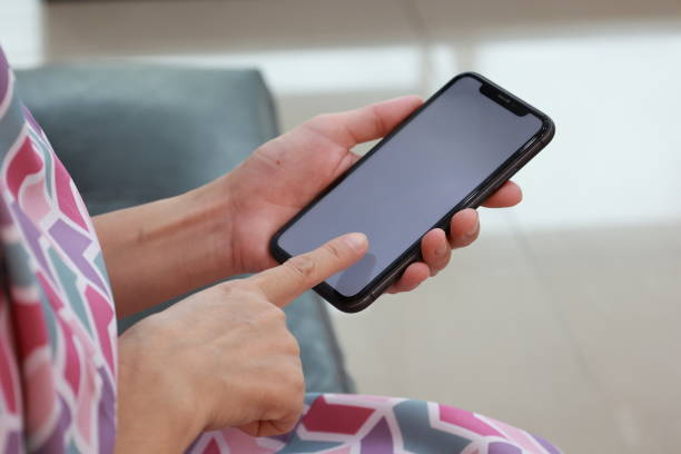 istock Female hand using phone, holding mobile phone, hand using smartphone 1658939959