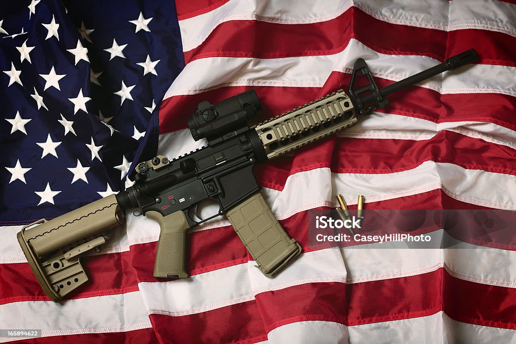 American AR-15 An AR-15 rifle with bullets on an American flag, a symbol of the right of patriotic Americans to bear arms, guaranteed by the Second Amendment. USA Stock Photo