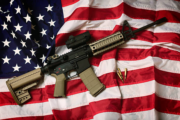 American AR-15 An AR-15 rifle with bullets on an American flag, a symbol of the right of patriotic Americans to bear arms, guaranteed by the Second Amendment. gun control photos stock pictures, royalty-free photos & images