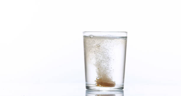 istock Tablets Falling and Dissolving into a Glass of Water against White Background 1658955860