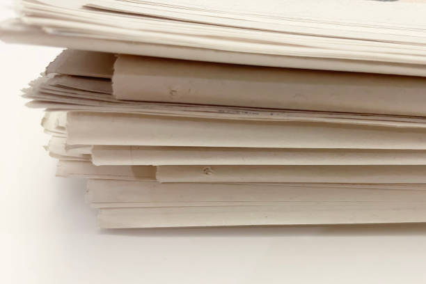 istock stack of old newspapers isolated on a white background. close-up 1658961209