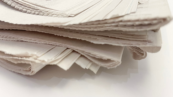stack of old newspapers isolated on a white background. close-up