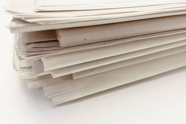istock stack of old newspapers isolated on a white background. close-up 1658962307