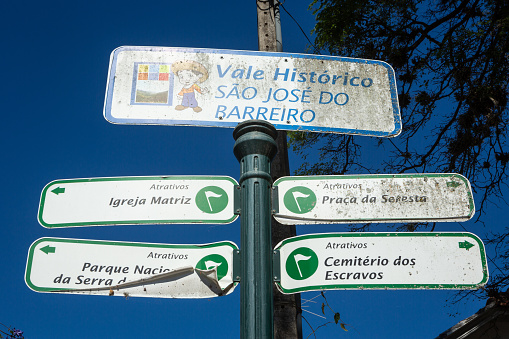 Historic valley sign of tourist attractions in the village square on a sunny summer day, São José do Barreiro, São Paulo, Brazil. Cemetery, Park, Church sign. Concept of tourism, travel.