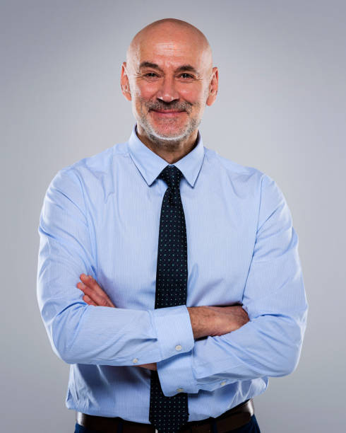 istock Smiling mid age businessman standing against a grey background 1658967757