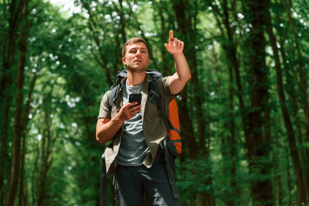 istock Searching the way, with smartphone for navigation. Tourist in summer forest. Conception of exploration and leisure 1658971568