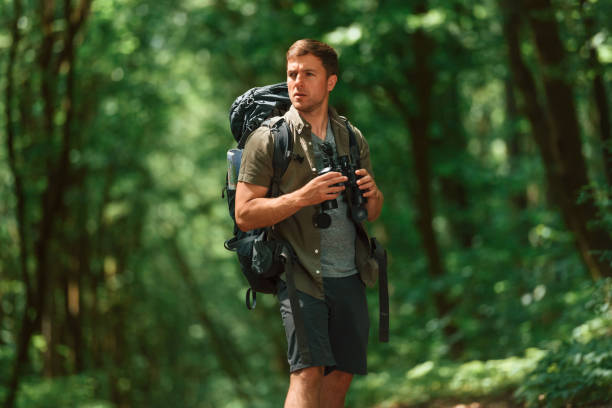 istock Navigation conception. With binoculars. Tourist in summer forest 1658973232