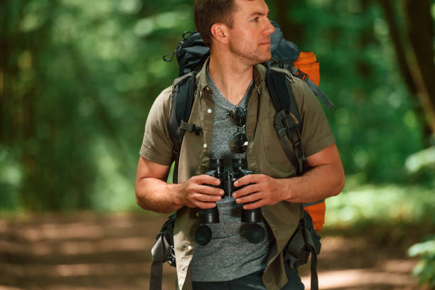 istock Navigation conception. With binoculars. Tourist in summer forest 1658973234