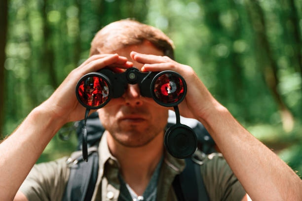 istock Looking through the binoculars. Tourist in summer forest. Conception of exploration and leisure 1658976649