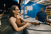 Young woman playing carnival games and shooting targets