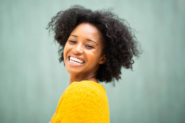 istock Smiling young black woman against green background 1658997666
