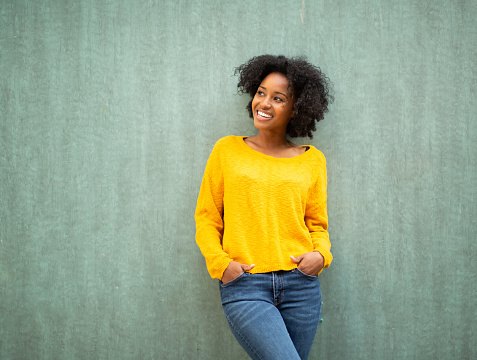 Portrait of beautiful young african american woman posing against green background
