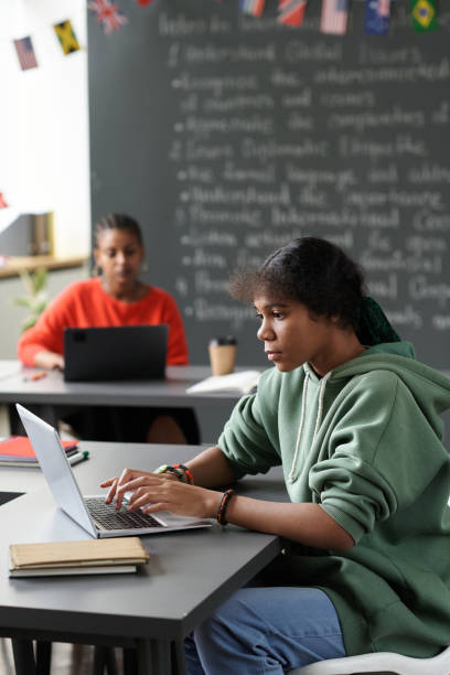 istock Schoolgirl typing on laptop at lesson 1659000629
