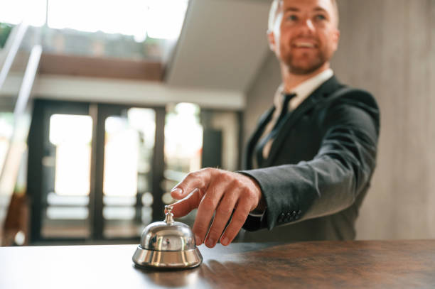 istock Standing, using hotel desk bell. A man in a black jacket at the hotel reception 1659002889