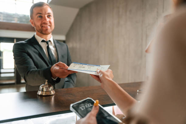 istock Woman serves a visitor. A man in a black jacket at the hotel reception 1659003432