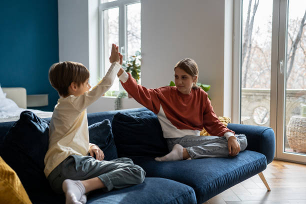 istock Older sister spending time with younger brother at home 1659019916