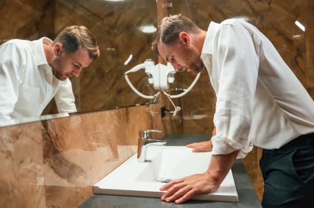 istock Man in formal clothes is in the bathroom against mirror 1659034612