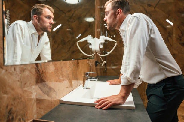 istock Man in formal clothes is in the bathroom against mirror 1659034622