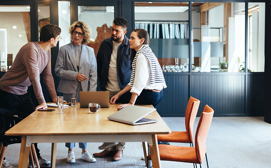 Design professionals having a meeting in an office. Group of business people discussing a project in a boardroom. Teamwork and collaboration in a modern workplace.