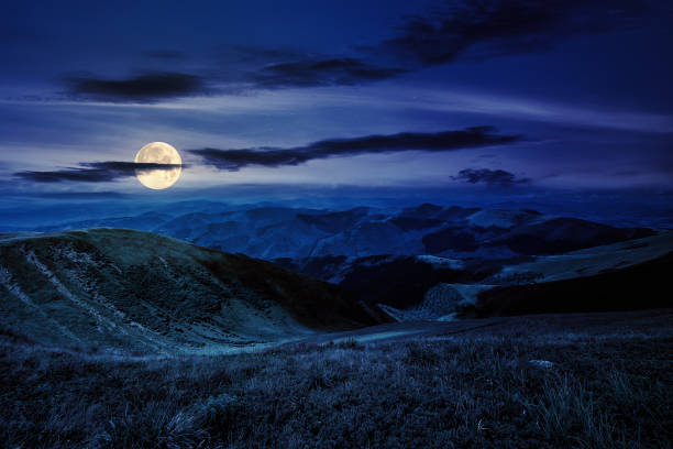 istock grass on hillside meadow in high mountains under the cloudy dark blue sky at night 1659046646