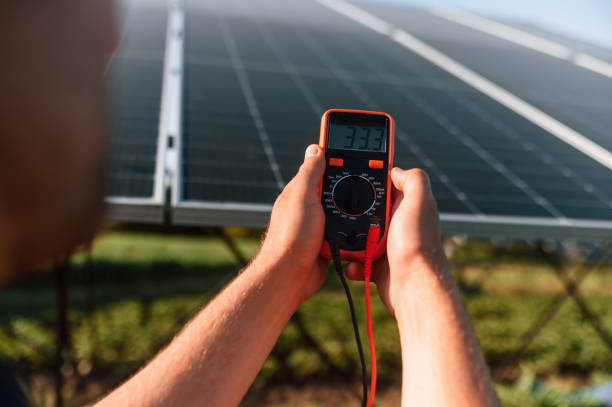 istock Measuring the electricity by using device. Man is doing operating and maintenance in solar power plant 1659047171