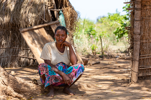 Belo Sur Tsiribihina, Madagascar - November 4. 2022: Malagasy woman in front of her hut resting in shaddow.