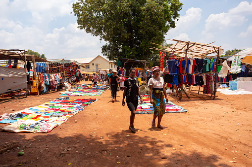 Mandoto, Madagascar - November 9th, 2022: A bustling street market in Mandoto city with vendors selling various types of clothes with vibrant colors.