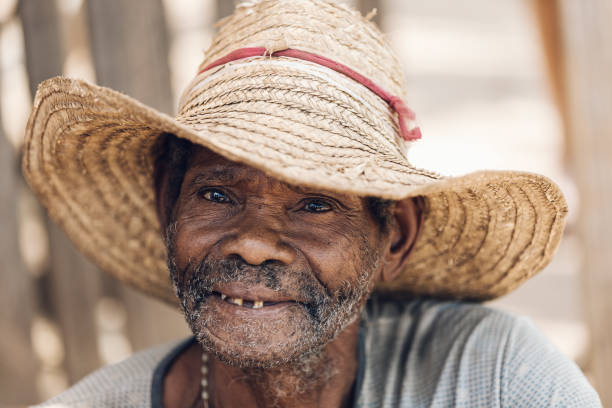 麦わら帽子をかぶって微笑む老人。ミアンドリバゾ, マダガスカル - africa senior adult friendship men ストックフォトと画像