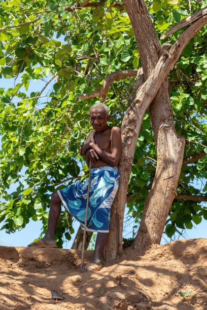 老人は、マダガスカルのベロスルツィリビヒナで川を渡るフェリーの近くの日陰で休んでいます - africa senior adult friendship men ストックフォトと画像