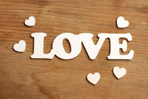 A love sign with white hearts on a wooden background with copy space
