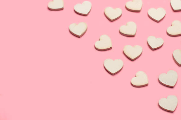 istock White wooden hearts on a pink background with copy space 1659056829