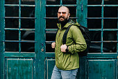 Handsome bearded man with a backpack in the street on an autumn day