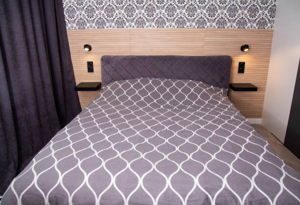 istock Modern bedroom interior with bed and headboard lamps. 1659059003
