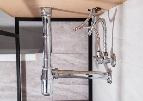 Modern stainless chrome siphon for draining water. Plumbing pipes. Drainage for draining water. Close-up