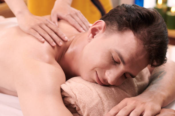 istock Young pleased man lying on couch and getting massage of back and shoulders 1659062802