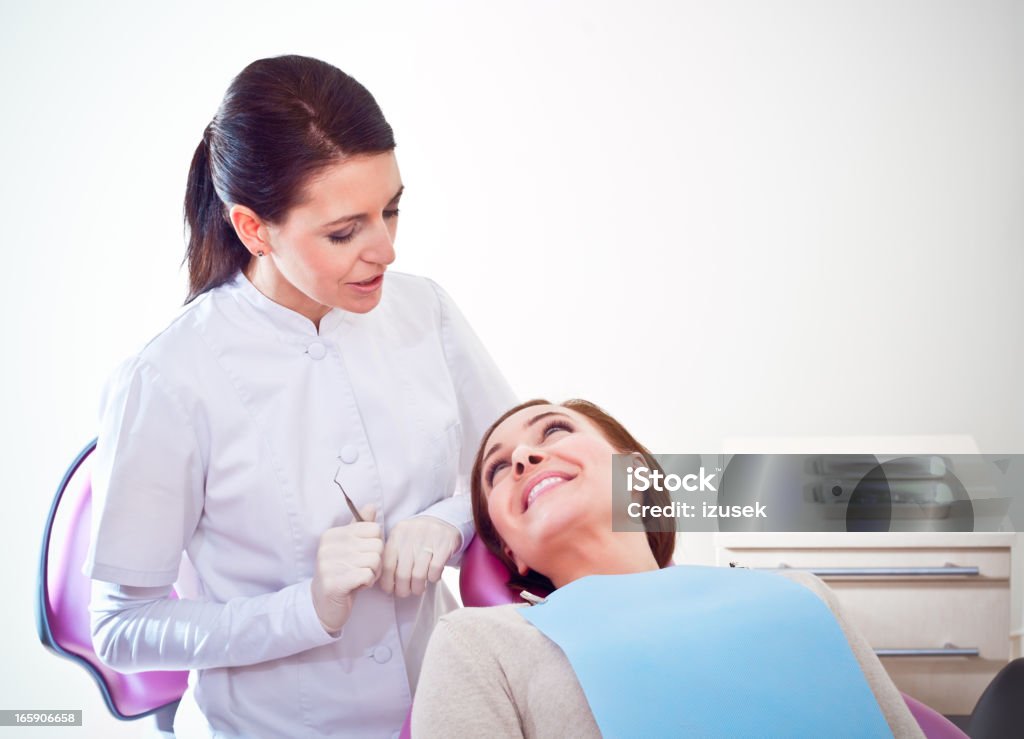 Dentista hablando con el paciente en la silla - Foto de stock de Dentista libre de derechos