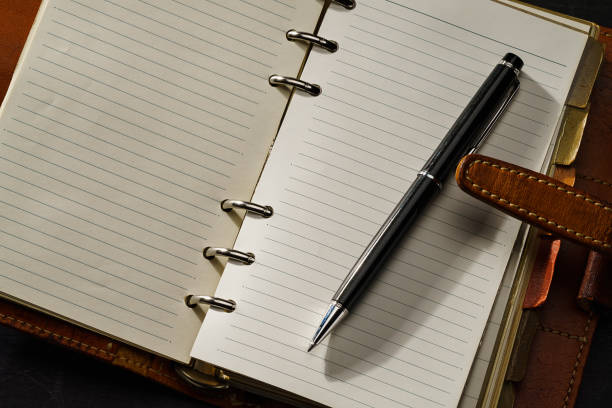 ring bound planner and pen on dark background - workbook personal organizer checklist diary imagens e fotografias de stock