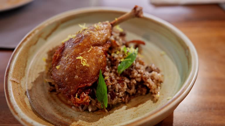 duck confit served with aromatic rice. The tender, flavorful duck and fragrant rice blend harmoniously, offering a sophisticated dish that epitomizes gourmet delight.