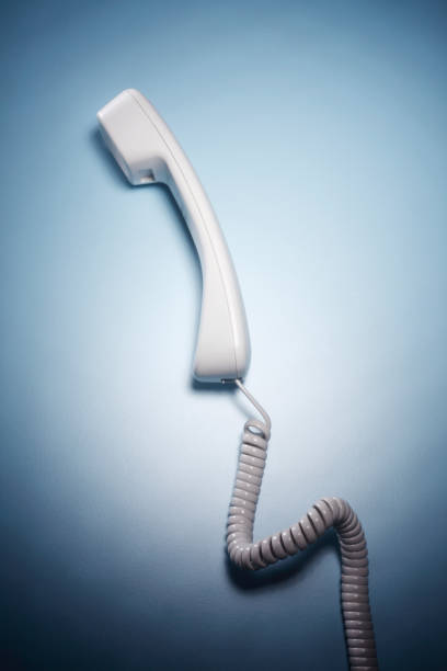 телефонная трубка на синем фоне - telephone telephone receiver phone cord telephone line стоковые фото и изображения