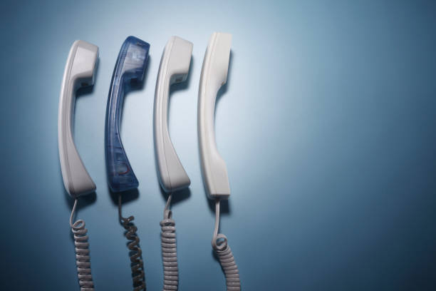 telephone receiver in a row blue color standing out from crowd