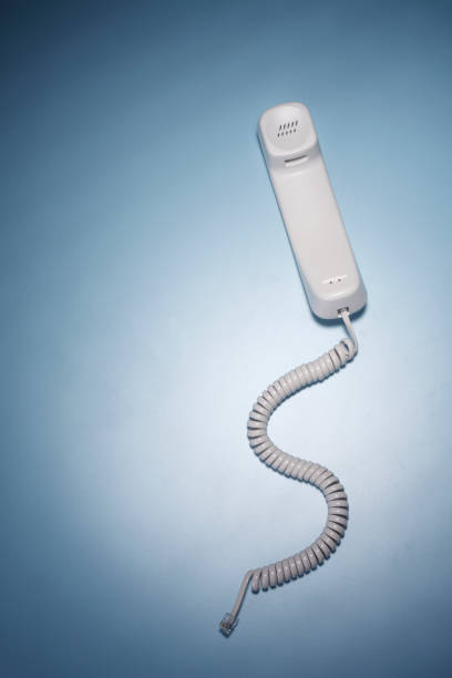 телефонная трубка на синем фоне - telephone telephone receiver phone cord telephone line стоковые фото и изображения