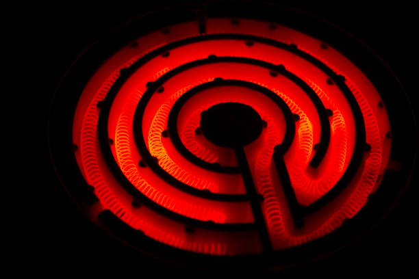 istock Retro electric stove with red heating wire (coiled nichrome wire) on a black background. 1659124560