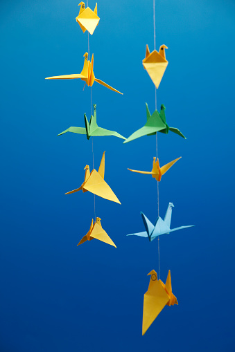 many of origami crane hanging  in a row