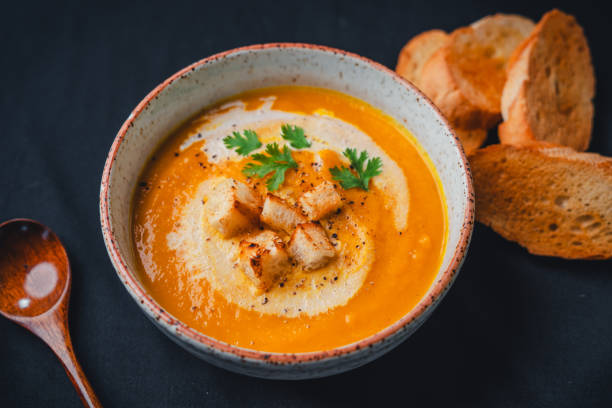 istock Pumpkin soup with cream on black background 1659128862