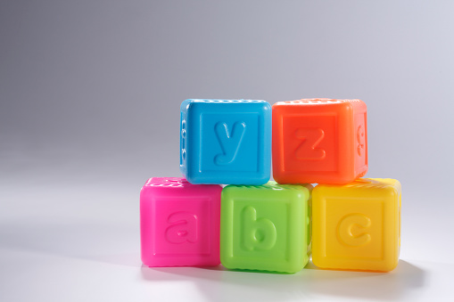 A stack of playing plastic alphabet blocks.