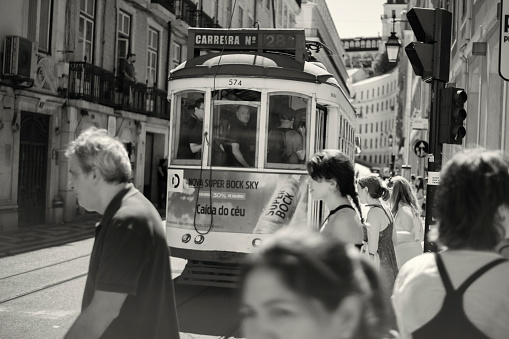 Lisbon, Portugal - July 29, 2023: A traditional tram runs along a street in Lisbon downtown.