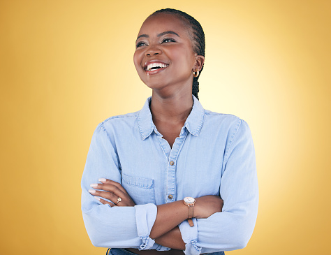 Thinking, idea and happy black woman confident arms crossed isolated in a studio yellow background. African, fashion and relax young person proud of style with a memory of joy, humor and fun